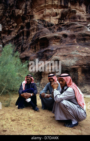 I beduini che indossa un rosso e bianco keffiyeh controllati in un burrone di arenaria in Khazali canyon nel deserto di Wadi Rum, conosciuta anche come la Valle della Luna, tagliato in arenaria e pietra di granito della Giordania Meridionale. Foto Stock