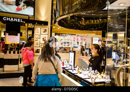 Donna di vendita fornendo informazioni di prodotto per i turisti nelle Galeries Lafayette, Paris, Francia Foto Stock