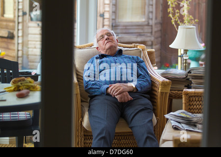 80 anno vecchio snoozing nel suo Conservatorio durante il pomeriggio, England, Regno Unito Foto Stock