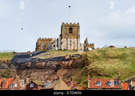 Le riparazioni che avvengono al collasso scogliera sotto la chiesa di Saint Mary, Whitby, nello Yorkshire, Regno Unito, aprile 2013. Foto Stock