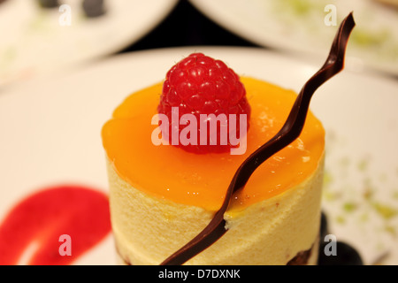 Deliziosa mousse al Mango torta guarnita con fragole e cioccolato Foto Stock