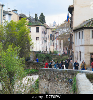 La gente che camminava sulla Carrera del Darro nel sole di sera, Granada, Spagna. Foto Stock