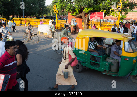 Un Sadhu indiano attraversando strade affollate a Nuova Dehli, in India Foto Stock