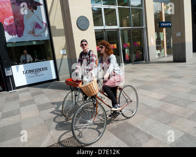 Persone in marcia retrò ciclismo su moto d'epoca nel centro di Cardiff Wales UK Foto Stock