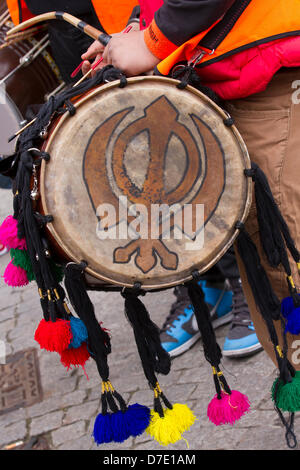 Sangar di Greater Manchester. Khanda firmare e Sikh batterista presso il Naga Kirtan Domenica 5 Maggio, 2013. La più importante celebrazione Vaisakhi nel calendario Sikh segnata dalla comunità sikh di maggiore e la loro annuale Nagar Kirtan processione per le strade di Manchester. Il Nagar Keertan è a colori, celebrazione e adorazione ed è un invito per tutti indipendentemente dalla casta, di religione e di credo per unire i sikh nel celebrare la loro religione e cultura. Foto Stock