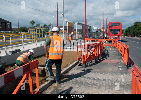 La posa di nuova pavimentazione pietre al cimitero Road Metrolink fermata del tram, Droylsden, Tameside, Manchester, Inghilterra, Regno Unito Foto Stock