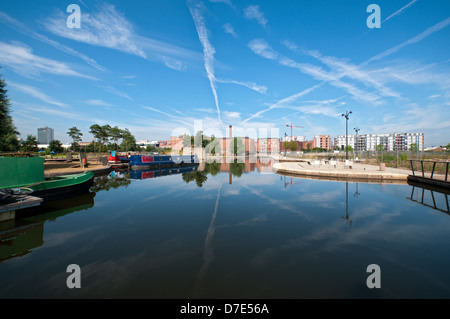 Cirrus cloud e ex Cotton Mills riflessa nel campo di cotone marina Park, New Islington, Ancoats, Manchester, Inghilterra, Regno Unito Foto Stock