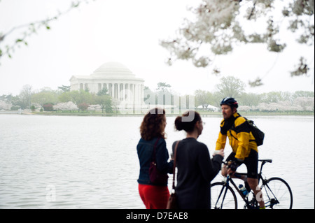 La nebbia, cool mattina di primavera in Washington DC con gente attiva godendo i fiori di ciliegio presso il bacino di marea. Foto Stock