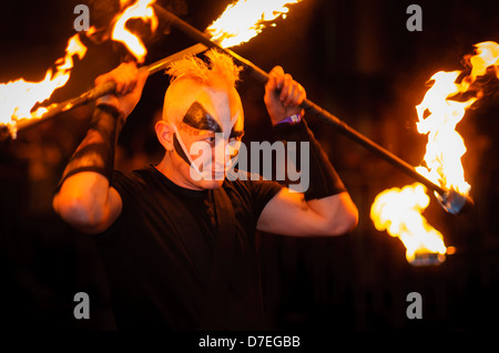 Uomo con vernice faccia eseguire con il fuoco in una sfilata Foto Stock