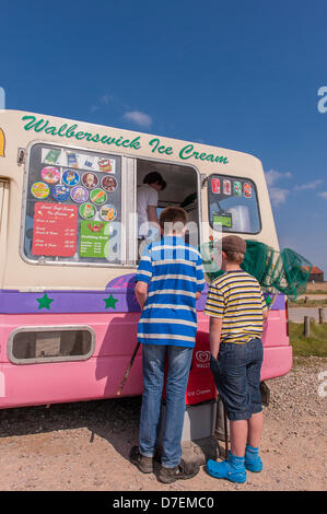 Walberswick, Suffolk, Regno Unito. Il 6 maggio 2013. Due ragazzi godetevi il sole sulla Bank Holiday lunedì 6 maggio 2013 come essi comprare gelati in Walberswick, Suffolk, Inghilterra, Regno Unito. Foto Stock