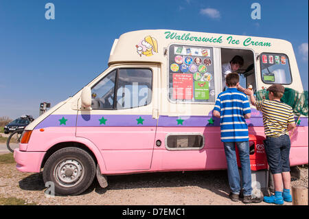 Walberswick, Suffolk, Regno Unito. Il 6 maggio 2013. Due ragazzi godetevi il sole sulla Bank Holiday lunedì 6 maggio 2013 come essi comprare gelati in Walberswick, Suffolk, Inghilterra, Regno Unito. Foto Stock