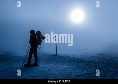 Silhouette di un alpinista in una nebbiosa nevicato paesaggio invernale, Polonia. Foto Stock