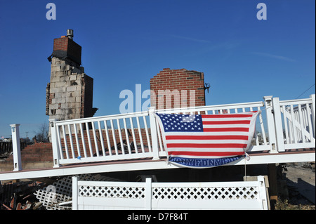 NEW YORK, NY - novembre 09: una bandiera americana vola da bruciato la casa in una zona danneggiata Foto Stock