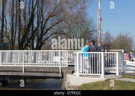 Due donne stand il funzionamento del pannello di controllo del piccolo ponte girevole sopra il canale Leeds-Liverpool in Crabtree Lane, Wigan Greater Manchester Foto Stock