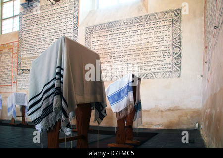 Preghiera scialli (Tallit) e le preghiere ebraiche scritta in ebraico sul muro a Tykocin (Tiktin) Sinagoga Foto Stock