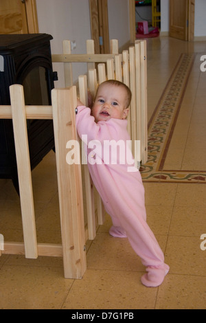 Un anno di età bambina che difficilmente può stare in piedi da sé Foto Stock