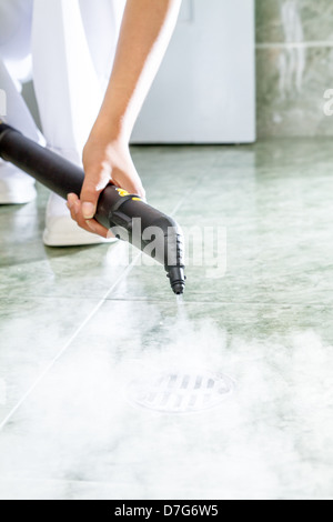 Donna di scarico di pulizia in bagno a vapore Foto Stock