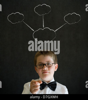 L'istruzione deve pensare boy vestito come uomo d affari con il pensiero di strategia chalk nuvole su sfondo blackboard Foto Stock