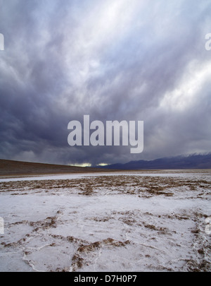 Badwater nella Valle della Morte salina con drammatica nuvole grigio Foto Stock