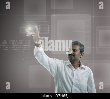 Asian commerciante indiano premendo high tech tipo di pulsanti moderno su un sfondo virtuale Foto Stock