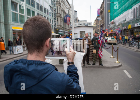 Giovani turisti fare fotografie con un Ipad al Checkpoint Charly Foto Stock