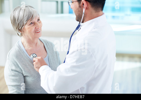 Fiducioso medico esaminando il suo senior paziente in ospedale Foto Stock