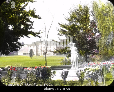 Un'immagine storica degli archivi *Oregon Agricultural College*, che mostra *The Fountain*, parte del campus universitario in Oregon. La fotografia cattura una caratteristica chiave del primo campus del college, evidenziando la fontana e il paesaggio circostante. Riflette la crescita del college e l'importanza degli spazi all'aperto nella vita universitaria durante i primi anni del XX secolo. Foto Stock