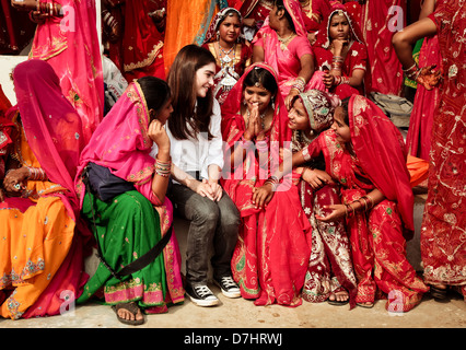 Straniero ragazza è accolta con favore dagli Indiani ragazze di Rajasthani a Pushkar fair, Rajasthan,l'India. Foto Stock