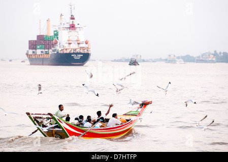 Lunghe barche che attraversa il fiume Irrawaddy durante le ore di punta, Yangon, Birmania (Myanmar) Foto Stock