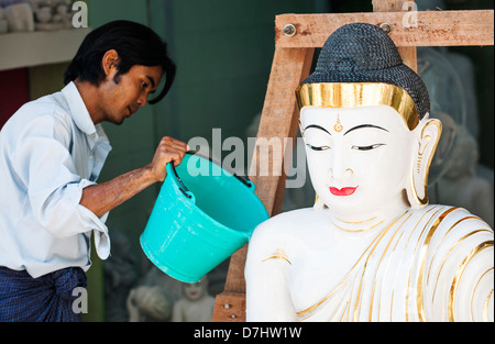 Un artigiano lavaggi in marmo statua del Buddha in un workshop di pietra, Mandalay Birmania (Myanmar) Foto Stock