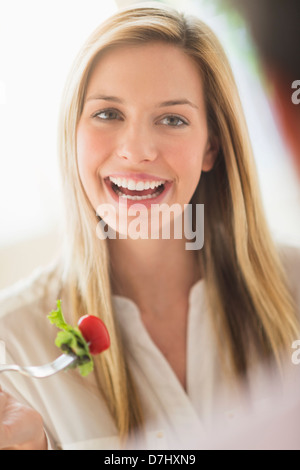 Donna di mangiare e ridere Foto Stock