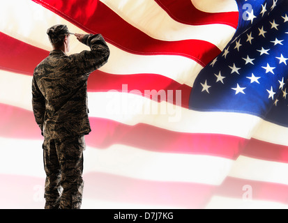 Soldato dell'esercito salutando davanti della bandiera americana Foto Stock