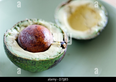 Avocado maturo tagliato a metà con sementi che mostra. Foto Stock