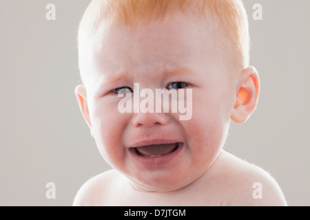 Studio shot ritratto di pianto baby boy (18-23 mesi) Foto Stock