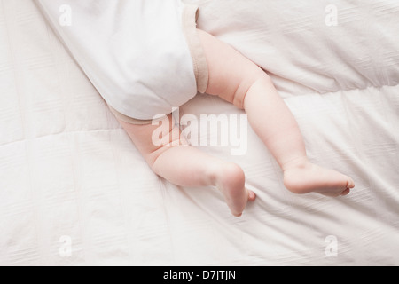 Sezione bassa di baby boy (18-23 mesi) giacente sulla parte anteriore Foto Stock