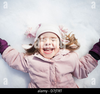 Ritratto di ragazza (2-3) sdraiato sulla neve Foto Stock