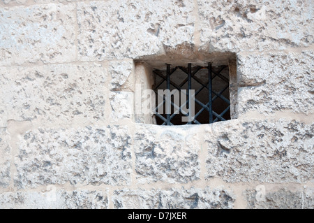 Finestra di piccole dimensioni con recinzione in ferro sul vecchio edificio. Foto Stock