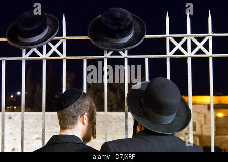 Gerusalemme, Israele. 8 maggio 2013. Due ultra-ebrea ortodossa guardare gli uomini come migliaia di religiosi sionisti celebrare a Gerusalemme il giorno in ballo annuale delle bandiere. Gerusalemme, Israele. 8-Maggio-2013. Più di cinquanta mila giovani appartenenti ai religiosi flussi sionista celebrare in ballo annuale delle bandiere esultanza l anniversario della riunificazione di Gerusalemme nel 1967 Six-Day-guerra in una dimostrazione di orgoglio ebraico. Credito: Nir Alon / Alamy Live News Foto Stock