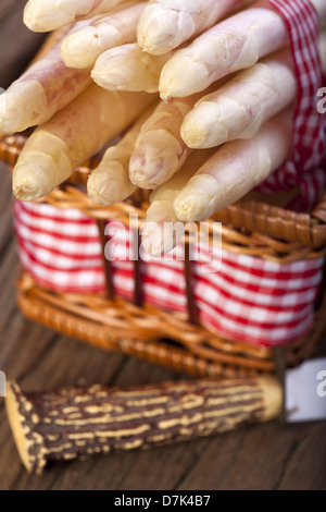 Asparagi bianchi legate con un nastro di tessuto in una cesta e un coltello con impugnatura in corno di bue Foto Stock