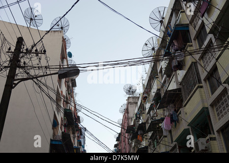 Gaunt street foderato con antenne paraboliche nel centro di Yangon, Myanmar 7 Foto Stock