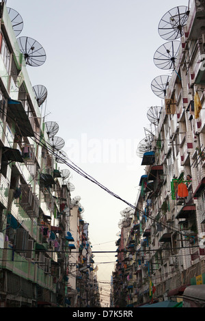 Gaunt street foderato con antenne paraboliche nel centro di Yangon, Myanmar 3 Foto Stock