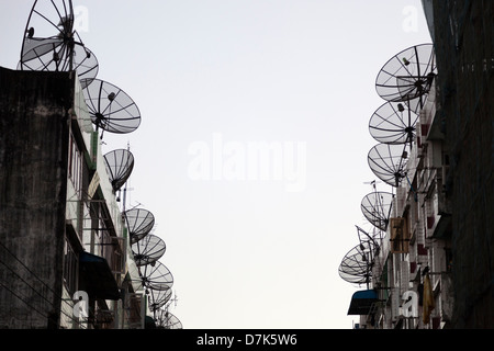 Gaunt street foderato con antenne paraboliche nel centro di Yangon, Myanmar Foto Stock