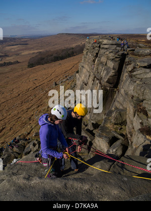 Arrampicatori preparando la marcia prima scalata verso il basso il bordo Stanage scogliera nel distretto di Peak DERBYSHIRE REGNO UNITO Foto Stock