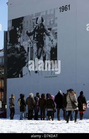 Berlino, Germania, persone a stare di fronte ad una scheda di informazione per la costruzione del muro di Berlino Foto Stock