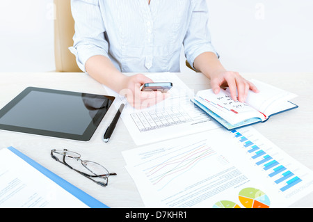 Imprenditrice di successo seduto alla scrivania in abiti casual e pianificare il suo giorno di lavoro in ufficio Foto Stock