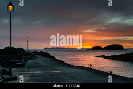 Sunrise a Ballintoy porto sul nord della costa irlandese Foto Stock