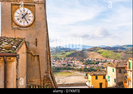 La torre dell'orologio di Sassocorvaro, vith una vista del piccolo paese di Mercatale in background Foto Stock