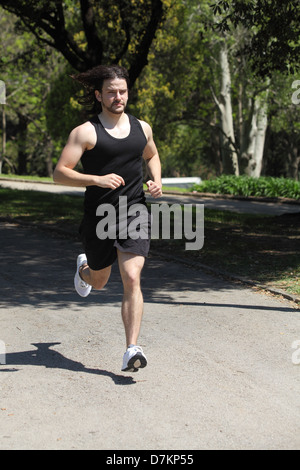 Vista frontale di un atleta in esecuzione su un parco Foto Stock