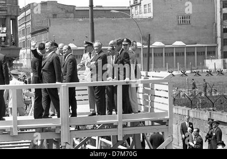 Il presidente statunitense John Fitzgerald Kennedy (r) in corrispondenza di un punto di vista presso il muro di Berlino il 26 giugno 1963. A destra sventolando sindaco Willy Brandt e accanto al presidente il Cancelliere tedesco Konrad Adenauer. Foto Stock