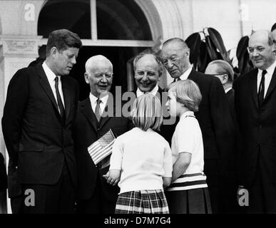 Il presidente statunitense John Fitzgerald Kennedy (l-r) e Presidente federale Heinrich Lübke sono accolti da due bambine, il 24 giugno 1963, sulla terrazza di Villa Hammerschmidt di Bonn. Ministro federale per la Cooperazione Economica Walter Scheel, Cancelliere federale Konrad Adenauer, usa il Segretario di Stato Dean Rusk, federale e il ministro degli Affari Esteri Gerhard Schröder (parzialmente coperto) erano anche presenti. Il presidente è stato in visita nella Repubblica federale per quattro giorni. Foto Stock